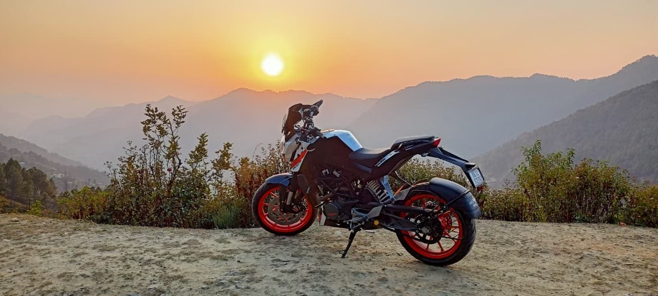 KTM Duke racing bike on rent in Dehradun with mountain sunset view